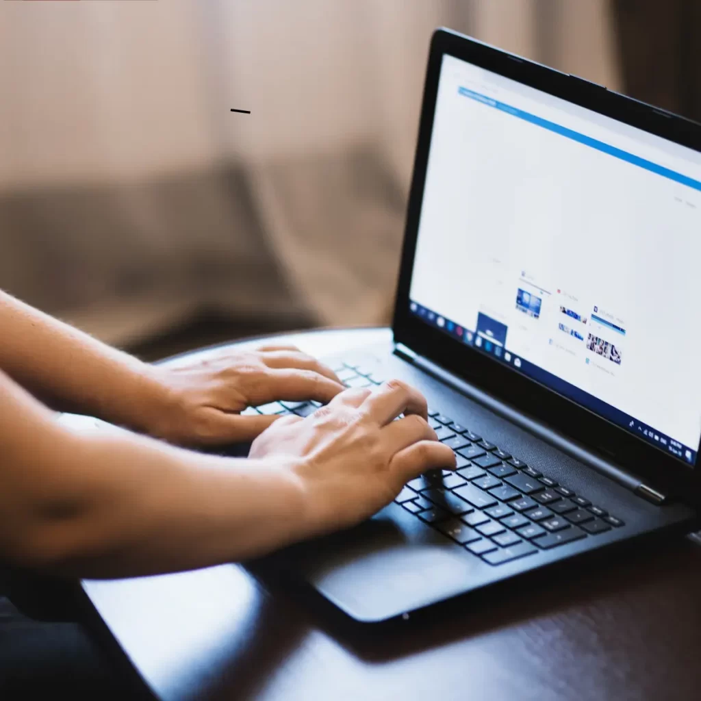 Una persona sentada escribiendo en una computadora.