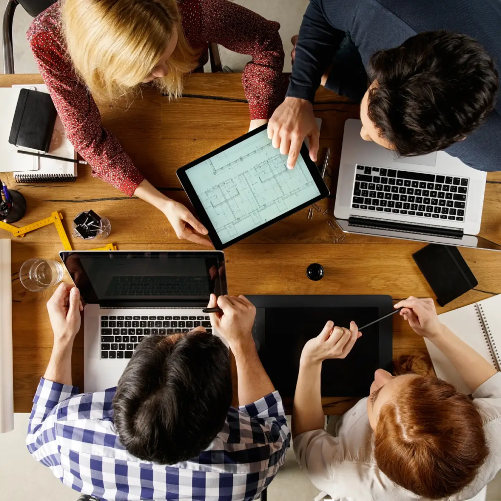 Imagen de personas reunidas revisando la pantalla de una table