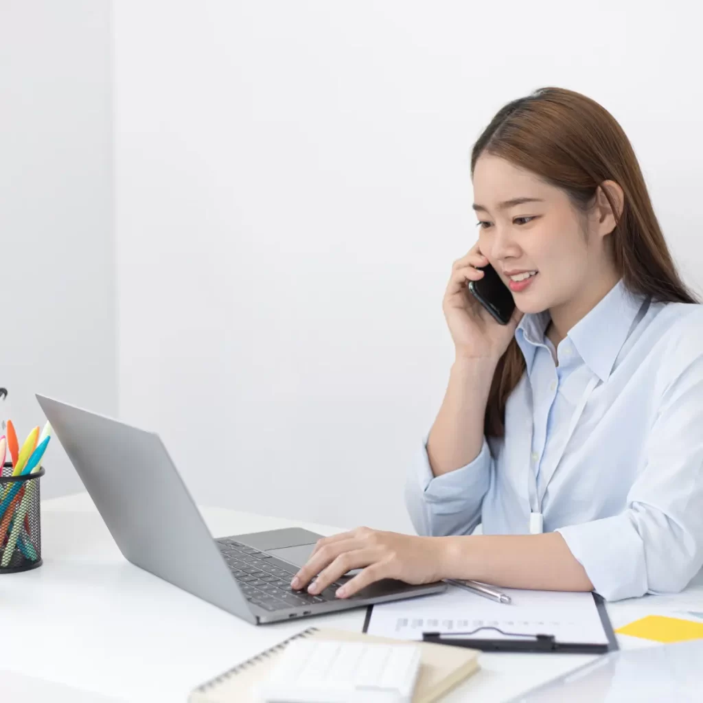 Imagen de una mujer en su escritorio reciebiendo una llamada telefonica