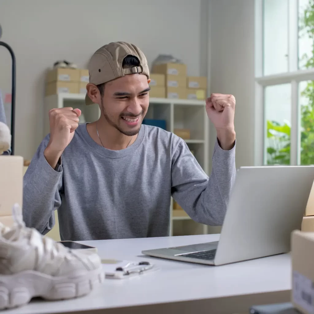 Imagen de una persona feliz viendola pantalla de su pc lo cual hace referencia a el SEO para ecommerce